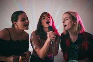 3 amies qui chantent lors d'un karaoké